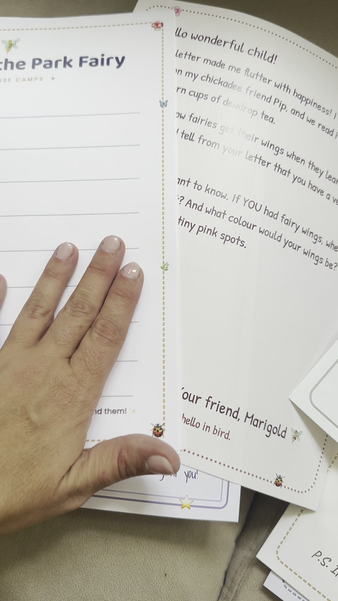 A hand holding handwritten Park Fairy letters from camp